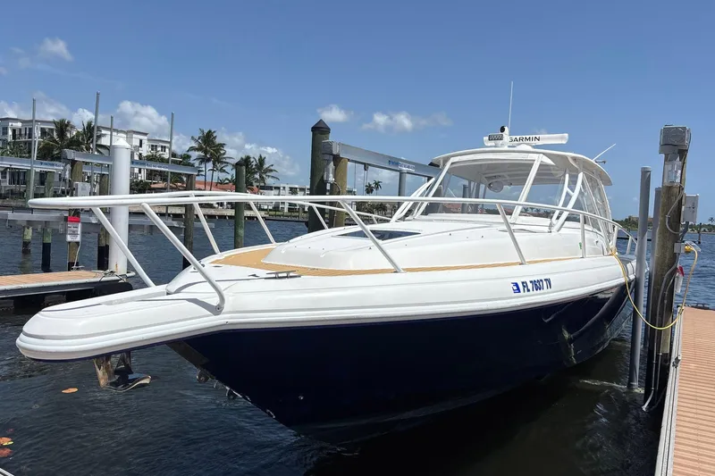 Slide: The Image of 2006 Intrepid 377 Walkaround boat docked at marina under clear blue sky. - 4