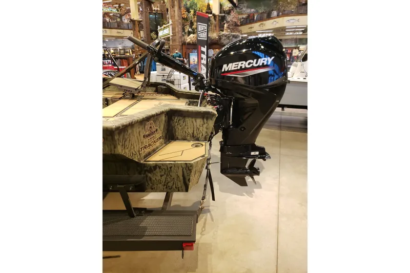 Slide: The Image of 2026 Tracker Grizzly 1756 T Marsh boat with Mercury outboard motor displayed indoors. - 5