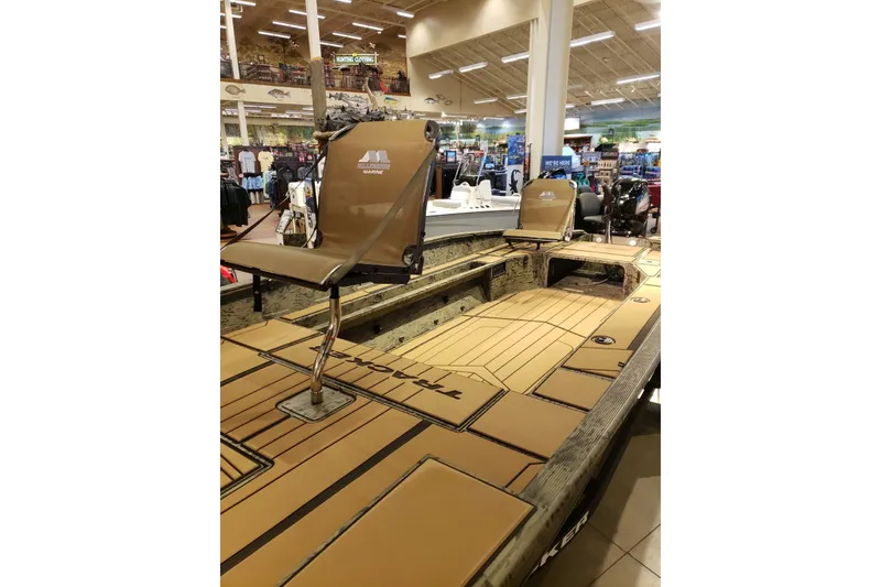 Slide: The Image of 2026 Tracker Grizzly 1756 T Marsh boat displayed in a showroom with seating and deck features. - 6