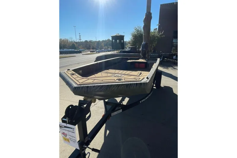 Slide: The Image of 2026 Tracker Grizzly 1650 T Prairie Wings Edition boat on trailer in sunlight. - 3