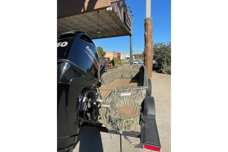 Slide: The Image of 2026 Tracker Grizzly 1650 T Prairie Wings Edition boat with camo design and Mercury engine. - 2