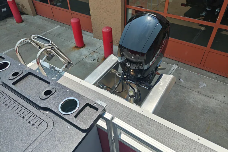Slide: The Image of 2026 Sun Tracker Sportfish 24 XP3 boat with Mercury outboard motor, docked at marina. - 18