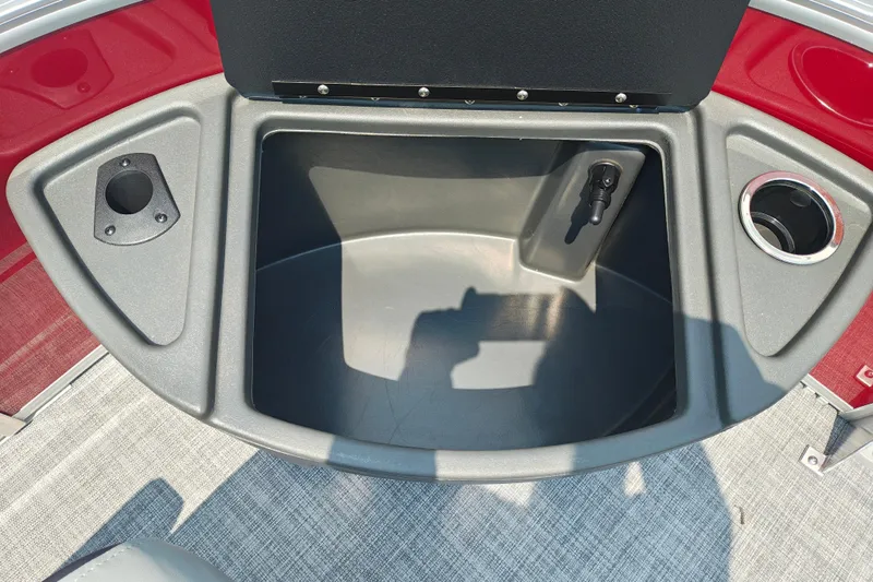 Slide: The Image of 2026 Sun Tracker Sportfish 24 XP3 boat storage compartment with cup holders and rod holder. - 29
