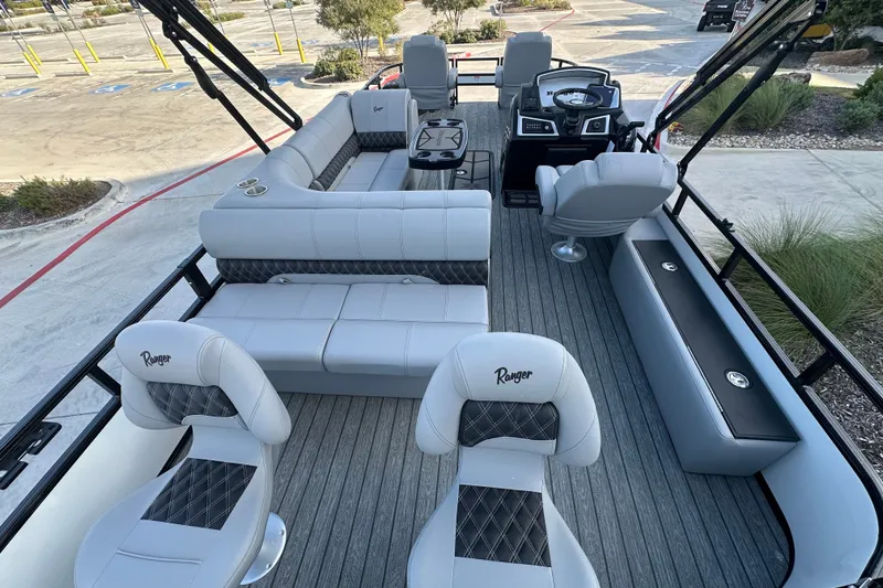 Slide: The Image of 2026 Ranger 223F boat interior with luxurious seating and modern dashboard in a parking lot. - 79