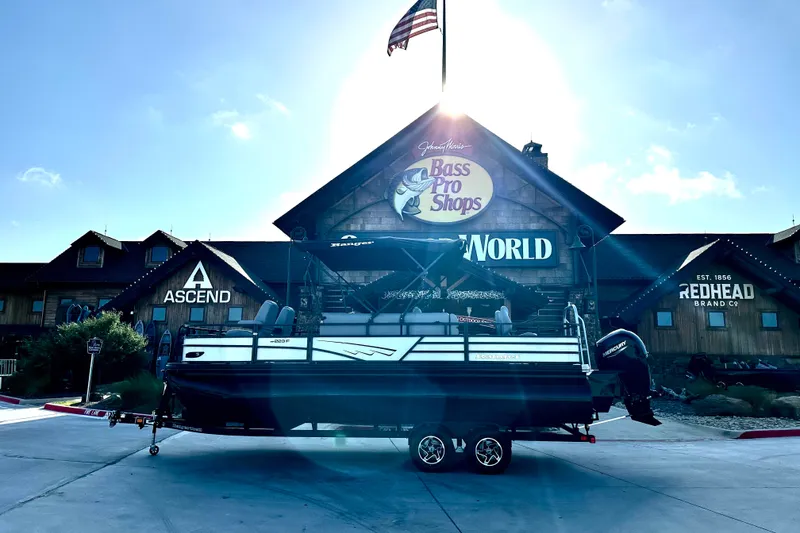Slide: The Image of 2026 Ranger 223F boat displayed outside Bass Pro Shops with American flag. - 86