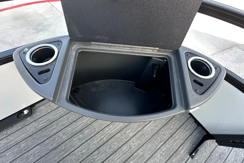 Slide: The Image of Open storage compartment with cup holders on a 2026 Ranger 223F boat. - 84