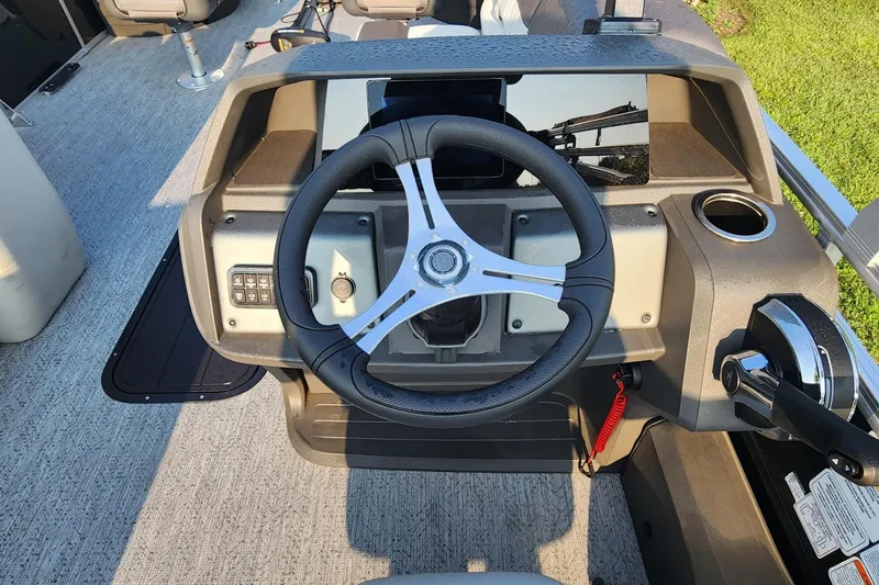 Slide: The Image of 2026 Sun Tracker Fishin' Barge 22 XP3 steering console with modern controls and cup holder. - 3