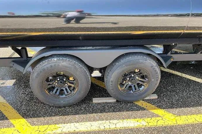 Slide: The Image of 2026 Ranger 220F trailer with dual black alloy wheels on asphalt. - 10