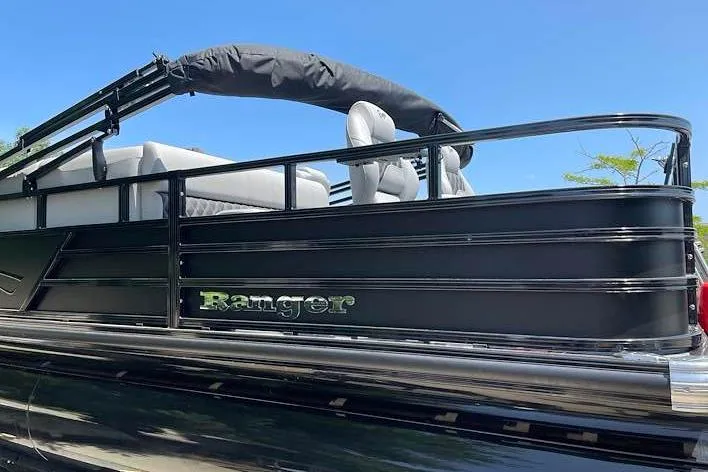 Slide: The Image of 2026 Ranger 220F pontoon boat with sleek black design and comfortable seating. - 2