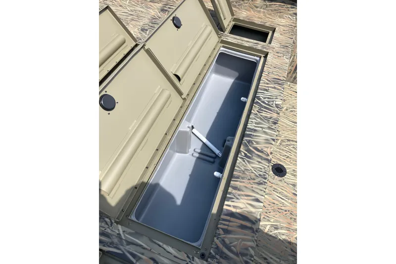 Slide: The Image of Open storage compartment on 2026 Tracker Grizzly 2072 CC boat with camouflage design. - 12