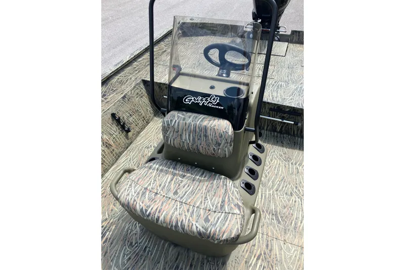 Slide: The Image of 2026 Tracker Grizzly 2072 CC boat interior with camouflage seating and steering console. - 8