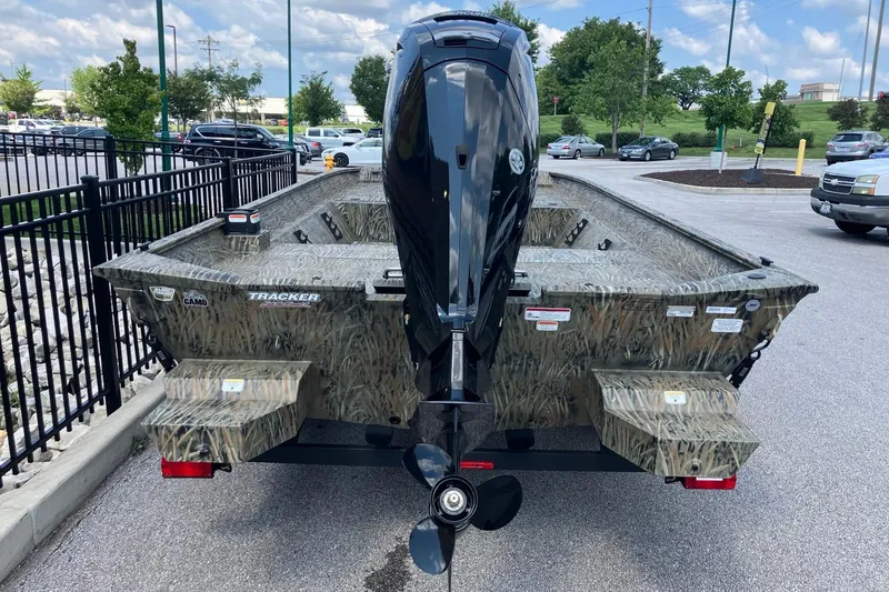 Slide: The Image of 2026 Tracker Grizzly 2072 CC boat with camouflage design, parked outdoors. - 2