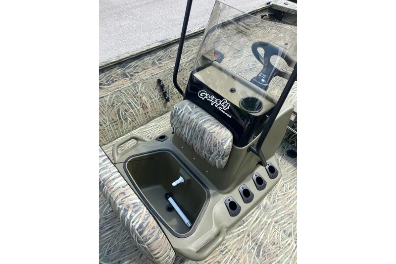 Slide: The Image of 2026 Tracker Grizzly 2072 CC boat interior with camouflage seating and steering console. - 9