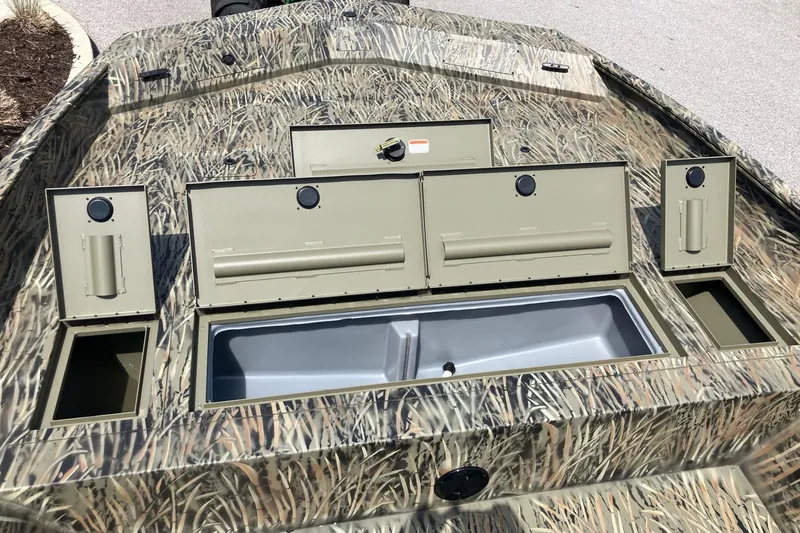 Slide: The Image of 2026 Tracker Grizzly 2072 CC boat with camo design and open storage compartments. - 11