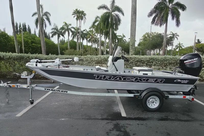 The Image of 2026 Tracker Bass Tracker Classic CC boat on trailer, parked near palm trees. - 0