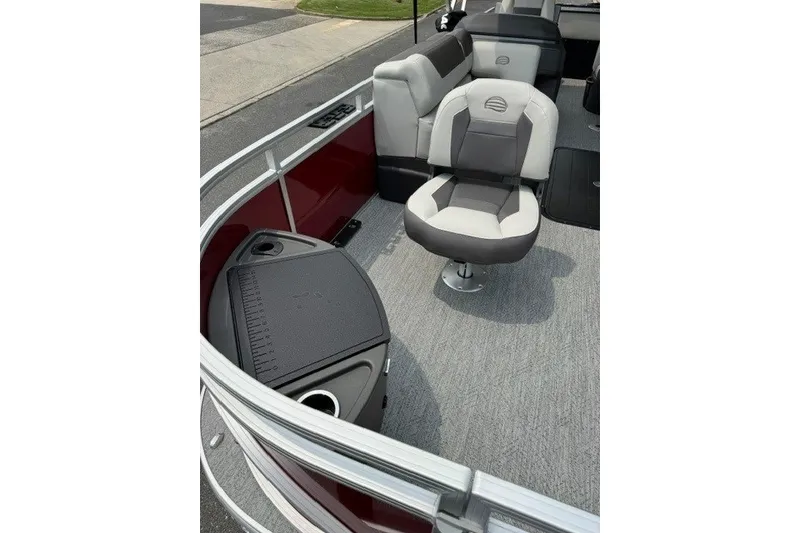 Slide: The Image of 2026 Sun Tracker Fishin' Barge 22 XP3 interior with swivel seat and storage compartment. - 13