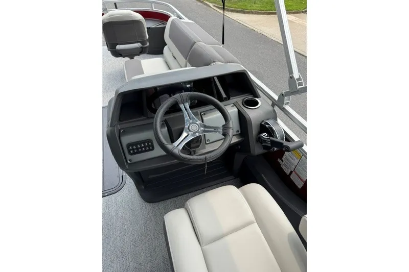 Slide: The Image of 2026 Sun Tracker Fishin' Barge 22 XP3 steering console with modern controls and seating. - 16