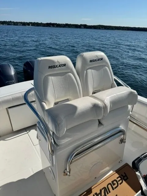 Slide: The Image of Two white seats with "Regulator" logo on a boat, surrounded by water. - 15