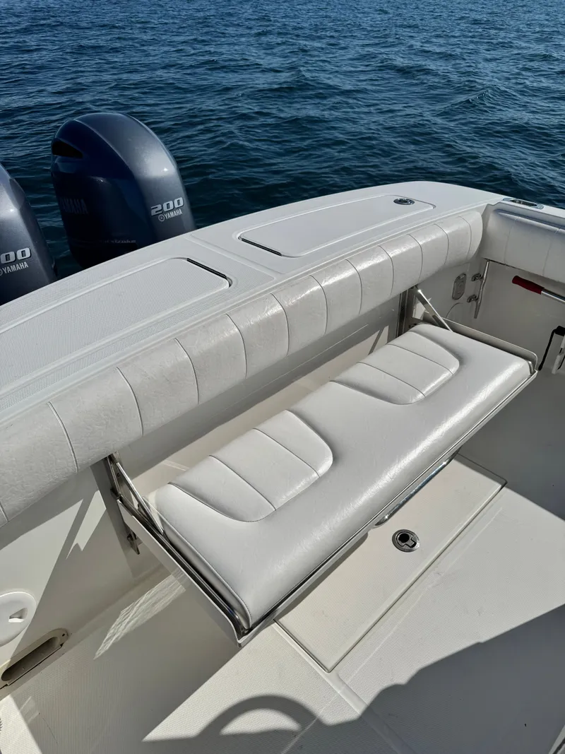 Slide: The Image of A white boat with a cushioned bench seat and two outboard motors on calm water. - 23