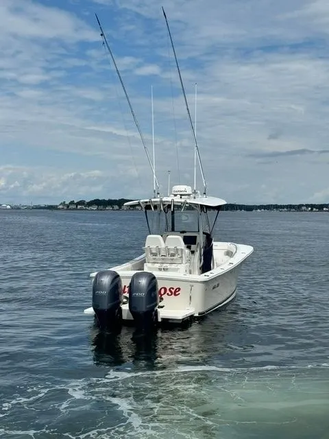 Slide: The Image of A 2015 Regulator 25 boat with dual outboard engines on calm water. - 8