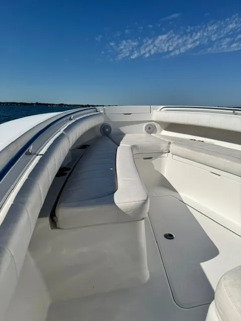 Slide: The Image of The image shows the bow area of a 2015 Regulator 25 boat with white upholstery. - 12