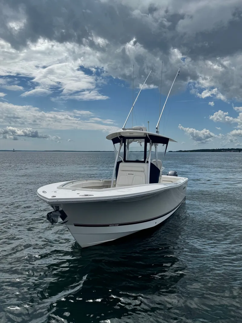 The Image of A 2015 Regulator 25 boat on calm water under a cloudy sky. - 0