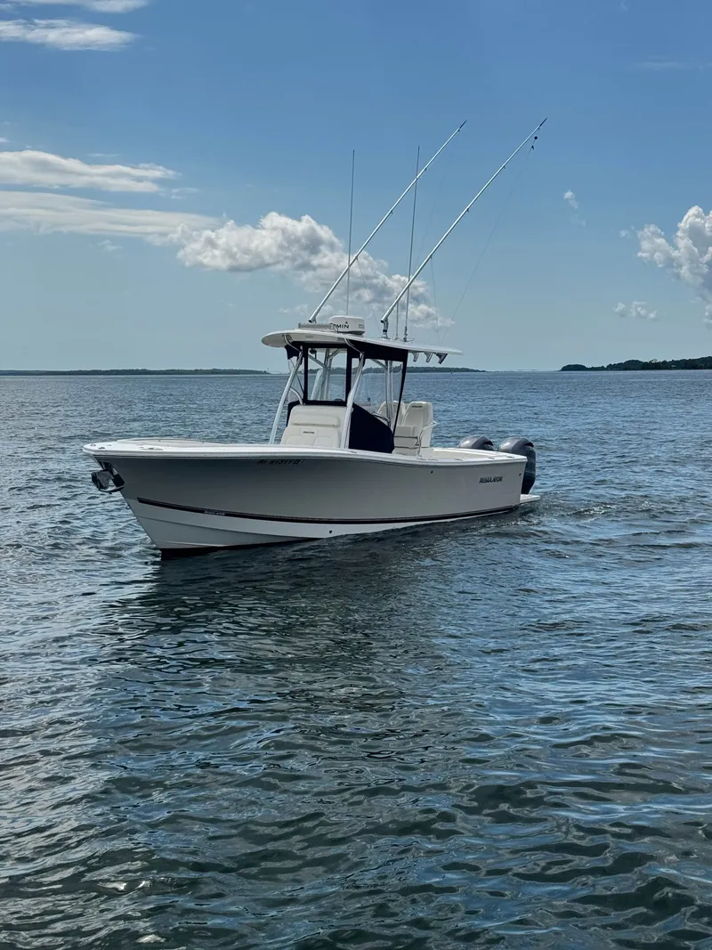 Slide: The Image of A white 2015 Regulator 25 boat floats on calm water under a blue sky. - 1