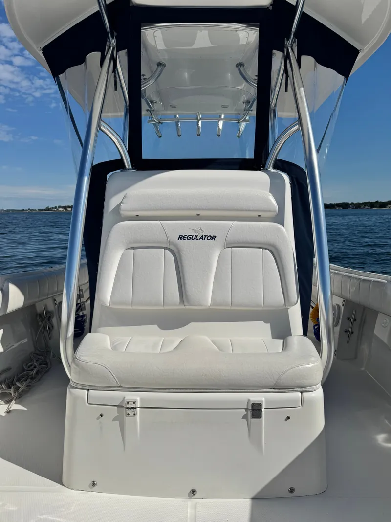 Slide: The Image of The image shows the cockpit of a 2015 Regulator 25 boat with white upholstery. - 20