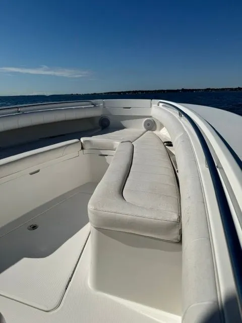 Slide: The Image of The image shows the bow area of a 2015 Regulator 25 boat with white cushions. - 13