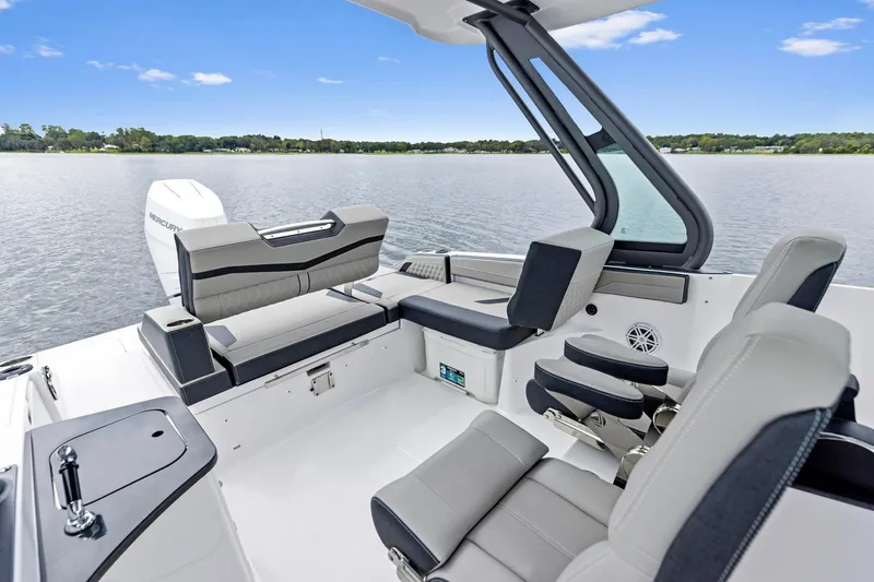 Slide: The Image of 2027 Monterey Elite 27 OB boat interior with modern seating and lake view. - 6