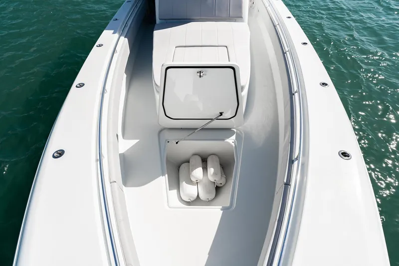 Slide: The Image of Manufacturer Provided Image: 2026 Contender 39 Fisharound boat deck with open storage compartment on calm water. - 4