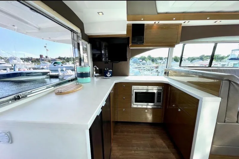 Slide: The Image of Luxurious interior of 2018 Cruisers Yachts 45 Cantius with modern kitchen and marina view. - 7