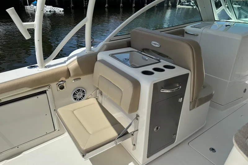 Slide: The Image of 2017 Sailfish 325 DC boat interior with seating and storage near water. - 9