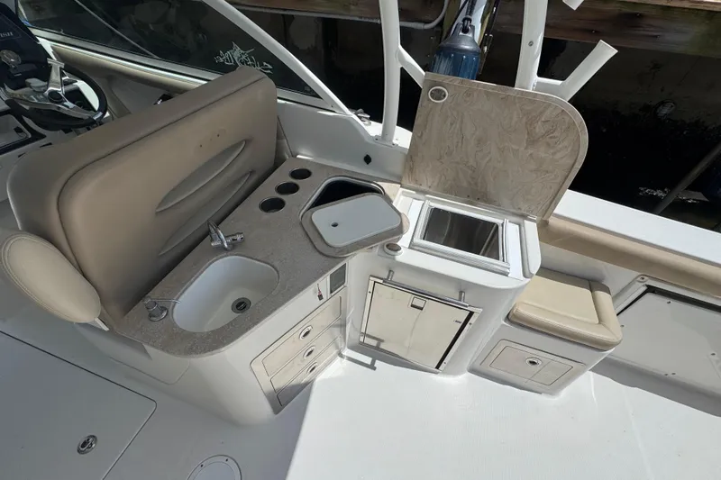 Slide: The Image of 2017 Sailfish 325 DC boat interior with sink, storage, and seating area. - 8
