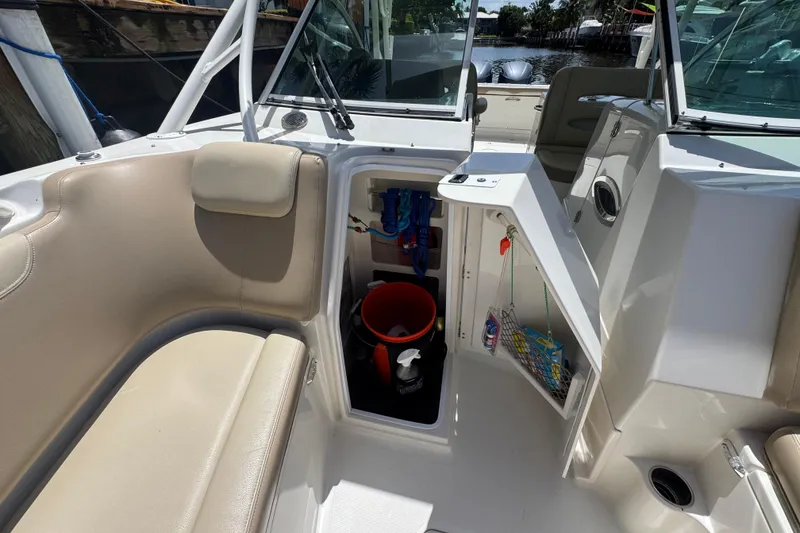Slide: The Image of 2017 Sailfish 325 DC boat interior with seating, storage compartment, and open hatch. - 21