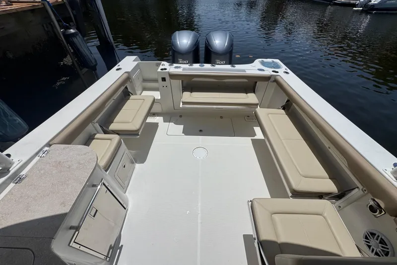 Slide: The Image of 2017 Sailfish 325 DC boat interior with seating and twin engines at dock. - 6