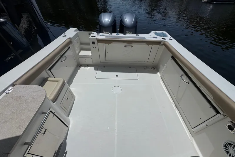 Slide: The Image of 2017 Sailfish 325 DC boat deck with storage compartments and twin engines. - 7