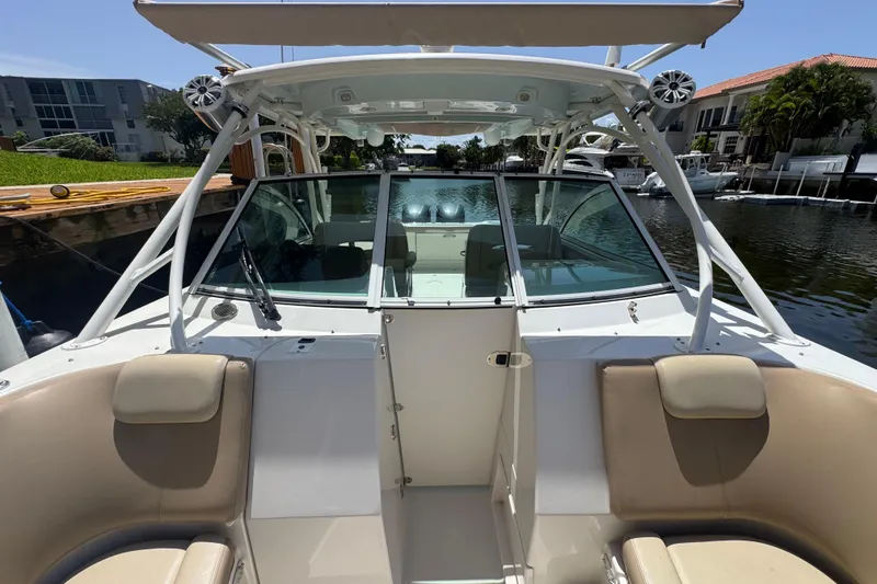 Slide: The Image of 2017 Sailfish 325 DC boat with seating, docked in a sunny marina. - 17
