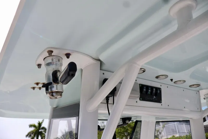 Slide: The Image of 2018 Sea Hunt Gamefish 27 Coffin Box boat interior, featuring control panel and rod holder. - 14
