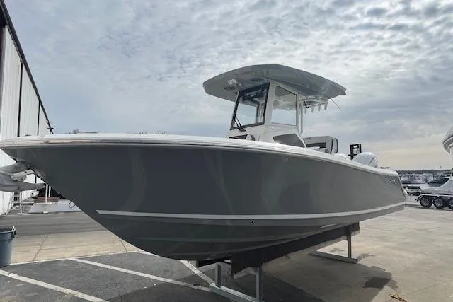 Slide: The Image of 2026 Cobia 245 Center Console boat displayed outdoors on a sunny day. - 1