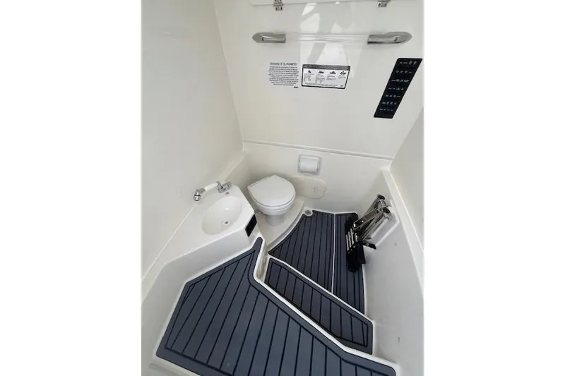 Slide: The Image of Interior of 2026 Cobia 245 Center Console boat, featuring a compact marine toilet. - 7