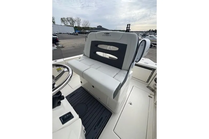 Slide: The Image of 2026 Cobia 245 Center Console boat interior with cushioned seating and steering wheel. - 11