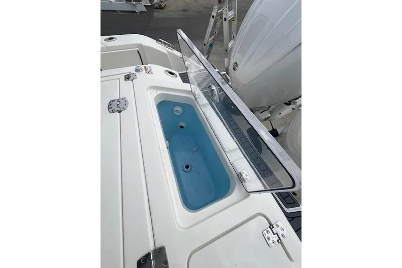 Slide: The Image of 2026 Cobia 245 Center Console boat with open livewell and engine view. - 17
