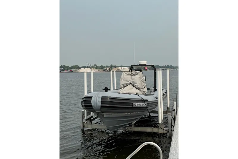 Slide: The Image of 1996 Willard Marine Sea Force 730 boat docked on a lift by the water. - 1
