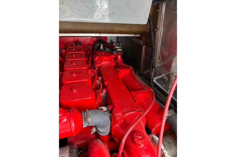Slide: The Image of Engine compartment of a 1996 Willard Marine Sea Force 730, featuring a red-painted engine. - 18