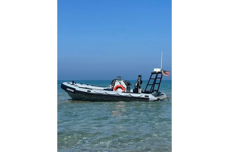 The Image of 1996 Willard Marine Sea Force 730 boat in clear blue water with American flag. - 0