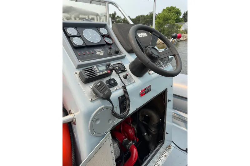 Slide: The Image of Control panel of a 1996 Willard Marine Sea Force 730 boat with steering wheel and gauges. - 14