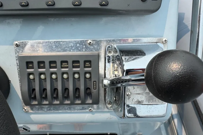 Slide: The Image of Control panel of a 1996 Willard Marine Sea Force 730 boat with switches and throttle. - 22