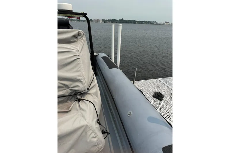 Slide: The Image of 1996 Willard Marine Sea Force 730 docked by the water, with covered seating. - 7