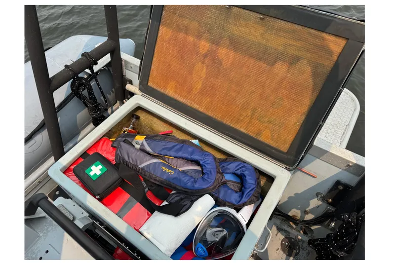 Slide: The Image of Open storage compartment on 1996 Willard Marine Sea Force 730 with safety gear and first aid kit. - 12